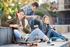 Three teenagers with smartphones