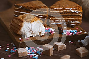 Three tender cake with coffee beans and bright powder on a gray wooden background. Selective focus, close up. background for postc