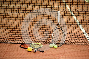 Three tennis rackets and balls on the indoor court photo