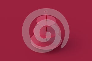 Three tiered dessert stand of magenta on red background photo