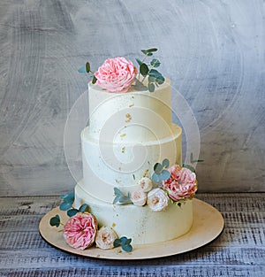 Three tiered wedding Cream cheese cake with roses and eucalyptus