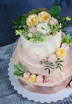 Three-tiered wedding ombre cake decorated with roses and greener