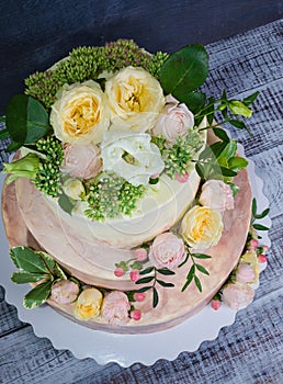 Three-tiered wedding ombre cake decorated with roses and greener