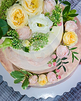 Three-tiered wedding ombre cake decorated with roses and greener