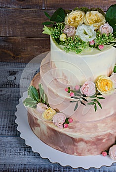 Three-tiered wedding ombre cake decorated with roses and greener