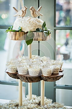 A three tiered wooden display with cupcakes