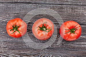 Three tomatoes on wood