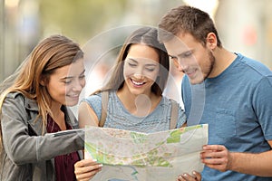 Three tourists consulting a paper map on the street