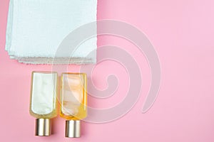 Three towels and body care oils stand on a green background. The concept of spa treatments, a healthy body