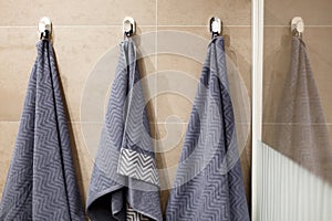 Three towels are hanging on the wall in the bathroom