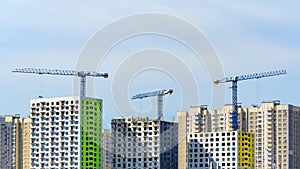 Three tower cranes build a modern panel houses