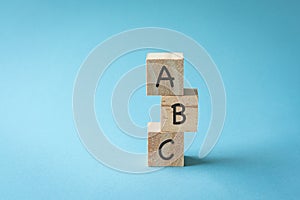 Three toy wooden blocks with letters ABC on them