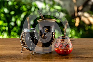 Three traditional mates made of calabash over a wooden table