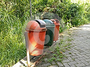 three trash cans by the roadside