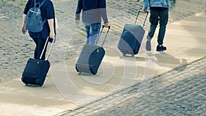 Three traveller tourist carrying their luggage on a pedestrian walkway. Top view and empty copy space