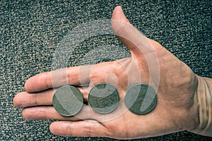 Three Tunisian coins on the woman's palm