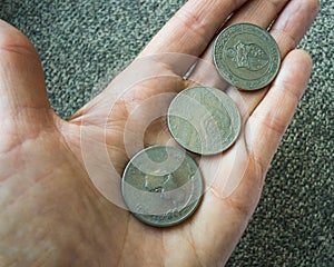 Three Tunisian coins on the woman's palm