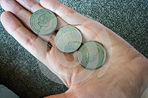 Three Tunisian coins on the woman's palm