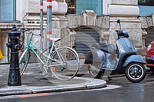 three type of vehicle parked at street bicycle moped scooter and car
