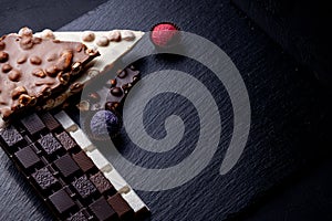 Three types of chocolate - black  milk and white with luxury handmade chocolates on a black background with copy space