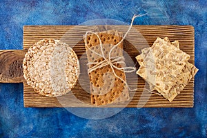 Three types of diet bread. Round buckwheat crispbread, wheat crispbread and crispbread with sunflowe on wooden vintage cutting