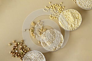 Three types of gluten-free flour on a beige background of millet, rice and buckwheat