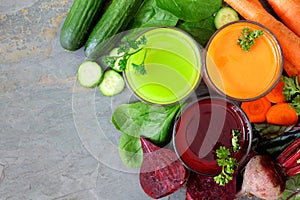 Three types of healthy vegetable juice, above view on slate