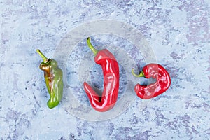 Three ugly red chili peppers on a blue grunge background, minimal style, creative food concept