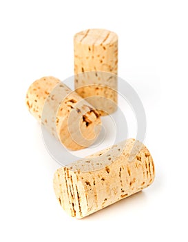 Three unused, new, brown natural wine cork on white