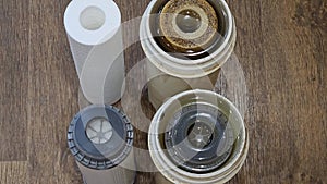 Three used water filters with traces of dirt, clay and contaminants. Replacing multi-stage water filter cartridges.