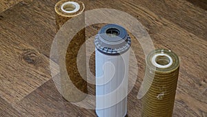 Three used water filters with traces of dirt, clay and contaminants. Replacing multi-stage water filter cartridges.