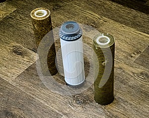 Three used water filters with traces of dirt, clay and contaminants. Replacing multi-stage water filter cartridges