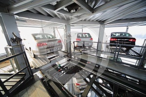 Three vehicles on the top floor of a transparent construction