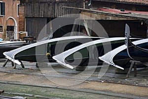 Three venetian gondolas in a dockyard