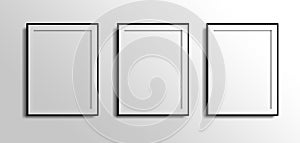 Three vertical fotos frames, 3d white blank on grey white wall with black borders. 3 fotos