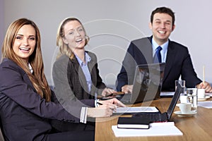 Three very happy business people sitting at table