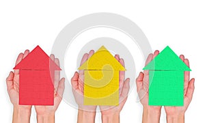 Three Vibrant Puzzle Houses in Hands on White