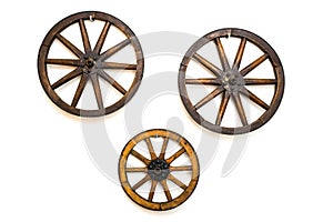 Three vintage wagon wheels on white wall