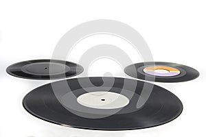 Three vinyl records of different sizes on white background