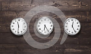 Three wall clocks on different time zones