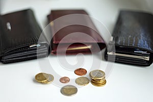 Three wallets  with several coins in the font