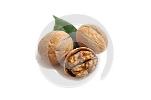 Three walnuts and a green leaf on a white isolate background
