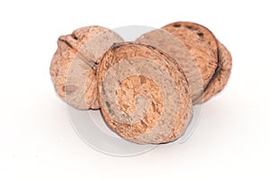 Three walnuts on a white background close-up macro, side view, copy space for text