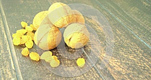 Three walnuts and a white isam lie on a wooden table. Still life