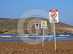 Three warning signs on prasonisi beach, rhodes, greece, no swimming because of big waves