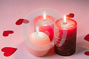 Three wax flame candlelight with paper red hearts valentines on white background, love dating, Valentine`s day