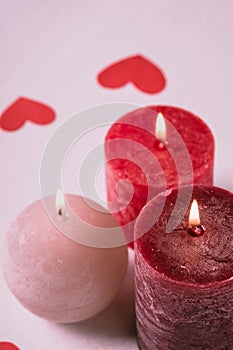 Three wax flame candlelight with paper red hearts valentines on white background, Valentine`s day