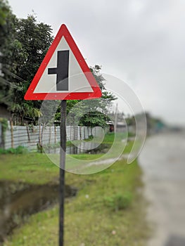 Three way junction warning sign board, intersection traffic sign on the roadside