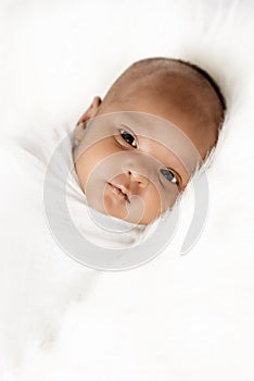 Three weeks old baby sleeping on white blanket cute infant newborn lying down close up shot eyes open