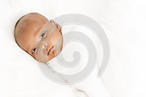 Three weeks old baby sleeping on white blanket cute infant newborn lying down close up shot eyes open